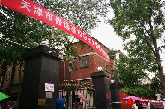 天津市第五十四中学考点外,不少家长撑伞站在门口等候、张望。崔新耀/摄